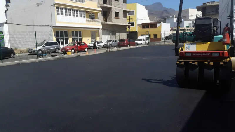 Rodillo compactador sobre asfalto recién extendido en una calle urbana
