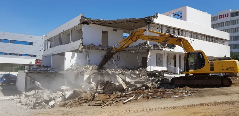 Excavadora de la empresa demoliendo un edificio